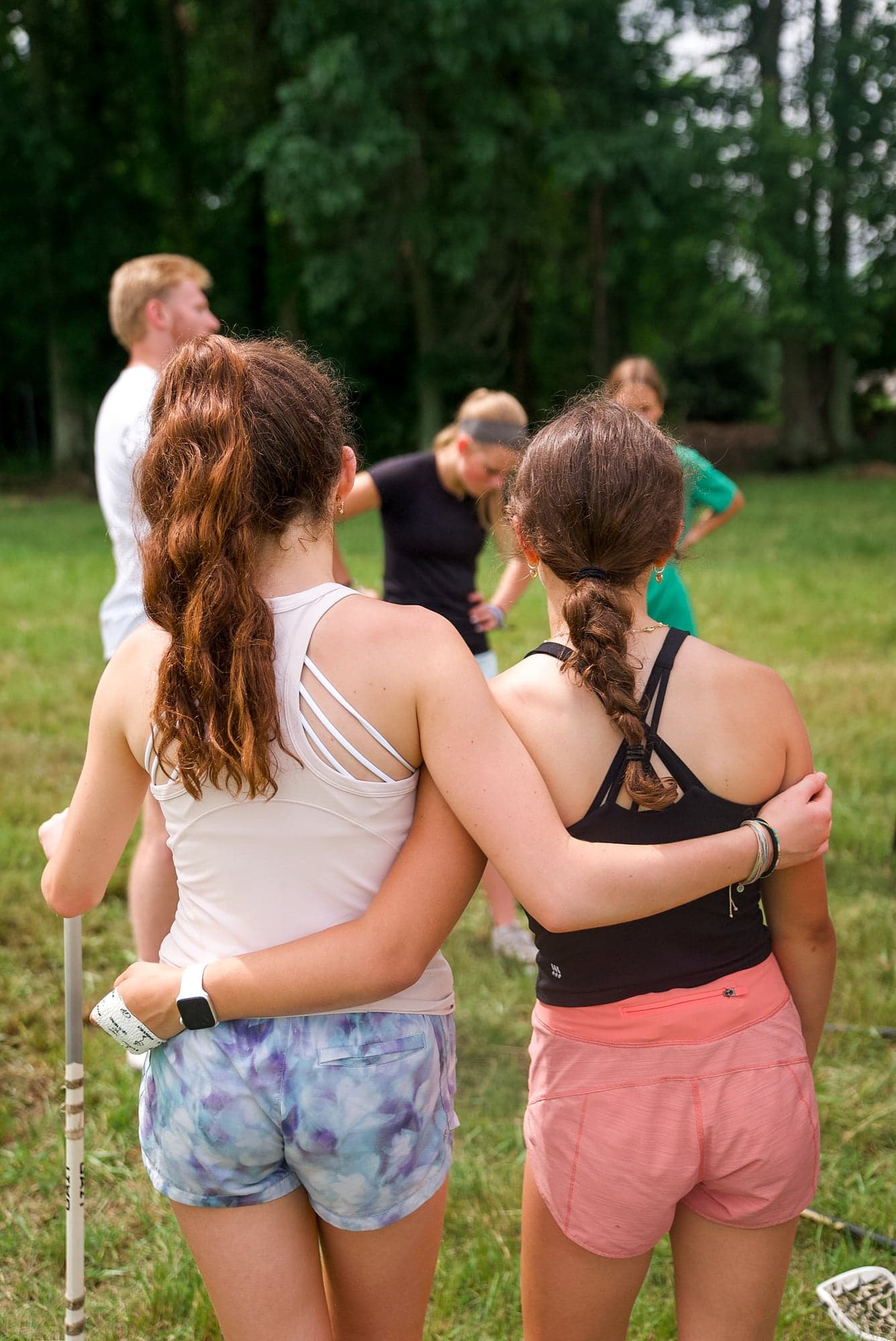 Two players arm-in-arm looking out at the field together