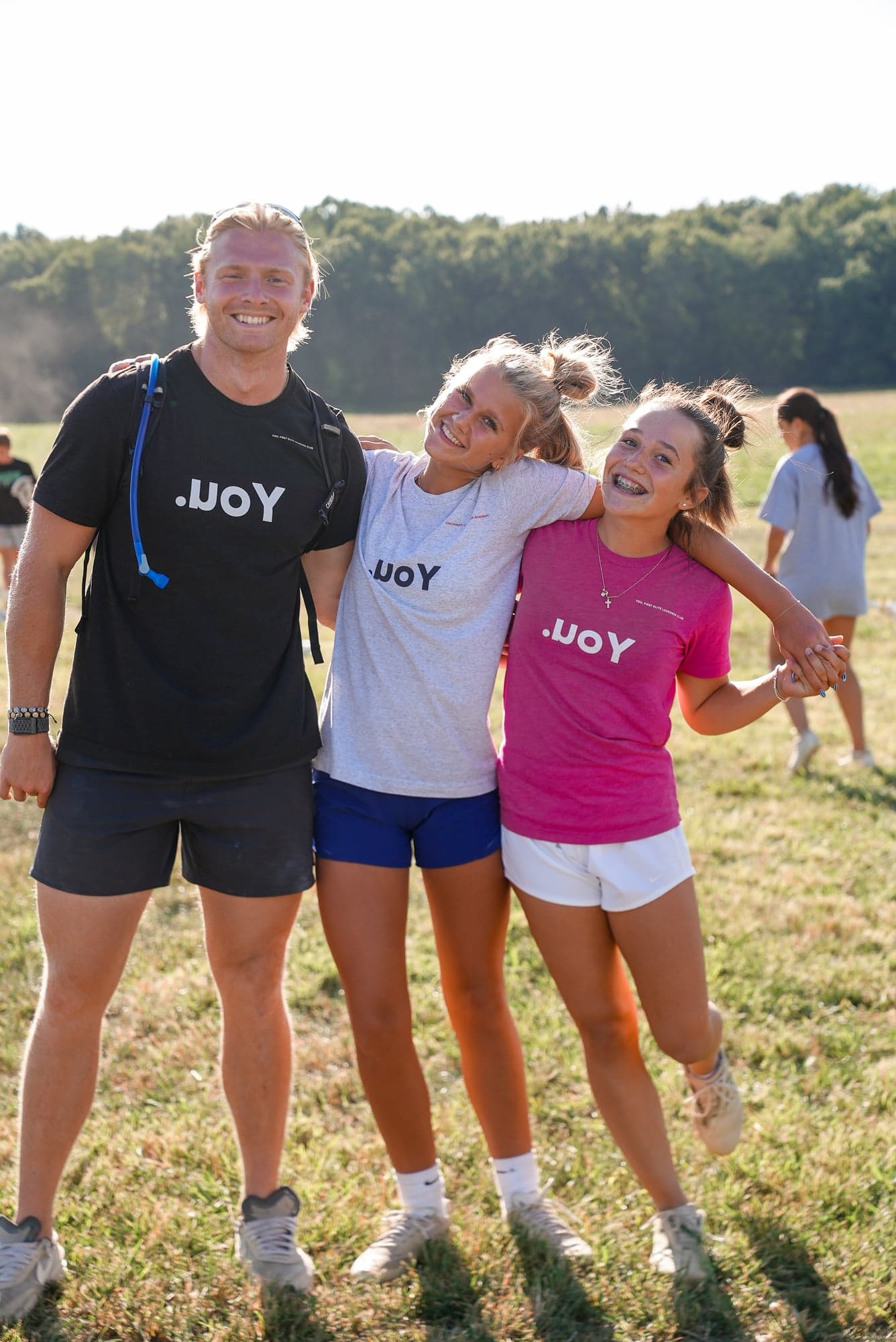 Coach and players laughing together at golden hour on the practice field