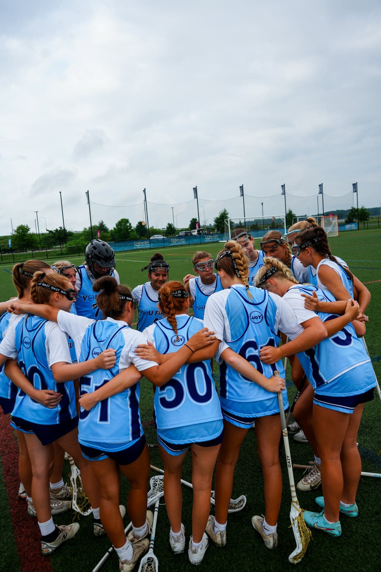 Team huddled together before a game under bright stadium lights